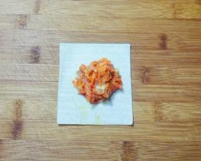 取一张馄饨皮，放适量胡萝卜肉馅