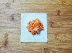 取一张馄饨皮，放适量胡萝卜肉馅