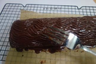 用刮刀将巧克力大致盖住蛋糕卷即可，再用刀叉挂出纹路，冰箱冷藏三小时以上