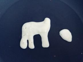 用面糊画图案，要根据盘子的大小调整，可以身体和头部分开做，也可以连在一起。（每一锅做完，最好将锅体离火，稍降温一下再开始下一锅。如果不做图案，做传统的圆形松饼，就无所谓了）