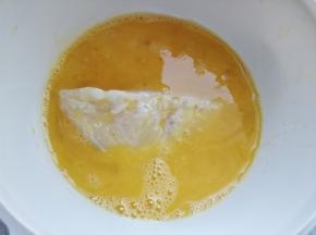将腌好的鱼柳放入蛋液中滚一下。