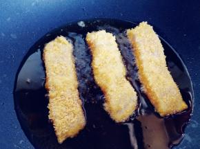 热锅热油，将鱼柳放入平底不粘锅中，先开中火，将一面煎至定型。