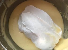 再加三分之一的蛋白入蛋黄糊，这时要用翻拌的手法，轻柔快速的搅拌均匀