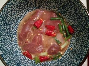 猪腰切开后，一定要片去猪腰上的“臊膜”，这点很重要，臊膜吃的会有怪味，用清水洗干净，再泡在调料里5分钟，清洗干净，切成花刀