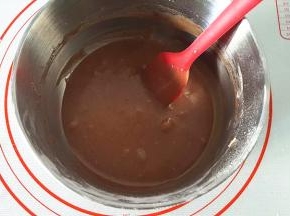 温热的黄油，分次倒入面糊中，用刮刀搅拌均匀，注意底下的油渣不要倒进去。