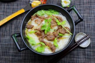 炒好的牛肉放入浓汤面上面，撒上香菜，即可；