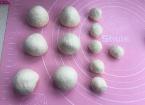 排气后，先分出12克一个的小面团，再把剩下的面团分成均匀6个，揉圆松弛10分钟