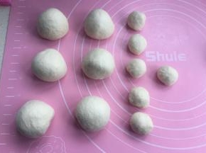 排气后，先分出12克一个的小面团，再把剩下的面团分成均匀6个，揉圆松弛10分钟