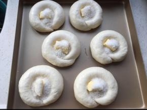 面团发到1.5--2倍，把黄油放中间，撒细砂糖