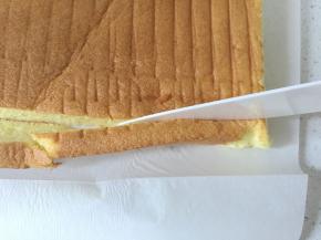 蛋糕卷取出后撕去油纸，倒扣放凉，用陶瓷刀切去边缘