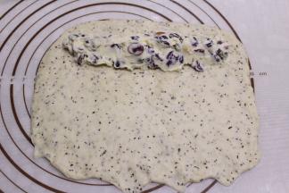 翻面后整理成方形，在上方放入1/3的馅料，下方要用手指压薄以便收口