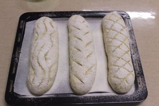 放入烤箱中进行二发，开启低温发酵功能，设置温度35度，底部加一碗温水，控制湿度在75度，约40分钟后取出，撒高粉割口