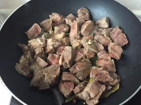 加入焯水的牛肉、淋入少许料酒