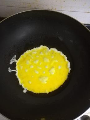 热锅加油，倒入鸡蛋，炒散。