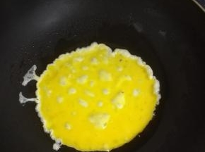 热锅加油，倒入鸡蛋，炒散。