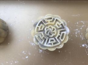 面团沾点熟糯米粉，用50克模具压制成型。烤箱预热上下火175度，先放入烤箱烤6分钟。