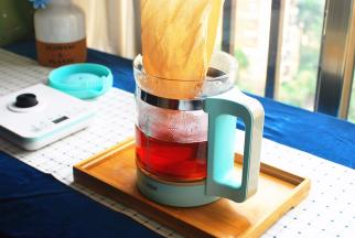 隔着茶袋，将茶壶里的红茶倒入玻璃壶中。盖上盖子，静置至茶温降为50度左右。