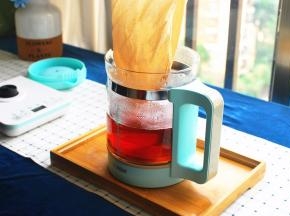 隔着茶袋，将茶壶里的红茶倒入玻璃壶中。盖上盖子，静置至茶温降为50度左右。