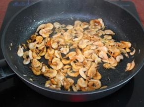 热锅，放少许油，倒入洗净的虾，葱白、姜粉煸香；
