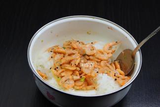 煸香好的虾仁倒入米饭中；