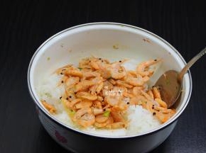 煸香好的虾仁倒入米饭中；