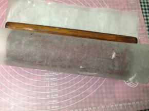 然后提起油纸用擀面杖辅助卷好