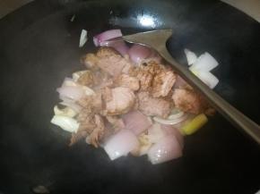 翻炒几下后，倒入卤牛肉