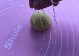 再揉成圆团，放在棉线相交点，如图提起处打结