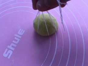 再揉成圆团，放在棉线相交点，如图提起处打结