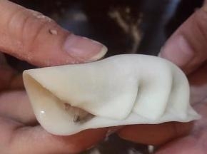 左手食指轻轻推一个皱褶去右手食指的位置，然后用右手两个手指把皱褶捏紧，重复步骤继续捏，左手拇指负责把馅往里面推一下。。给后面皱褶留位置，左手边推右手边捏紧
