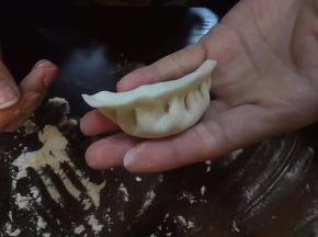 在保证馅都在里面不会跑出来时，拇指就可以轻轻扶着外面的皮子，继续捏