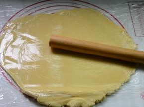 冷藏结束，放在保鲜膜中间擀开，擀成面饼