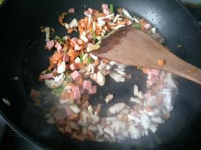 将香菇，火腿肠，胡萝卜倒入锅中，翻炒。