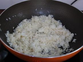 锅中放适量的油，倒入米饭爆炒；