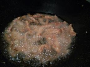 将里脊肉下锅中炸制表面微微变黄，捞出控油