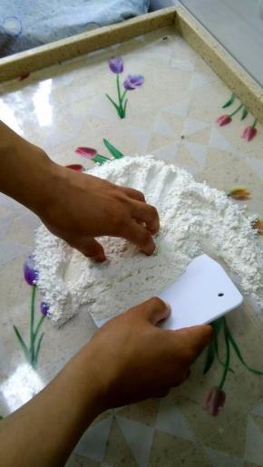 这个时候要学会使用刮板，一只手拿着刮板轻轻将面粉翻起