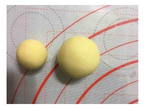 将面团分成两个大小不一的面团各9个，大面团50克，小面团19克。