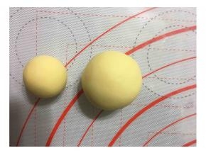 将面团分成两个大小不一的面团各9个，大面团50克，小面团19克。