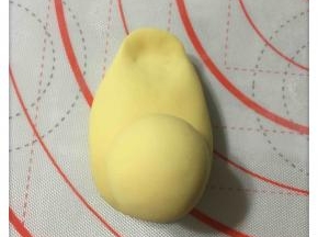 小面团揉成光滑的头部，然后头部与身体粘合的地方用手指沾少许水抹在面皮上，以便更好的粘连。
