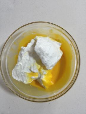 挖三分之一蛋白糊加入到蛋黄糊中翻拌，请看清楚是翻拌、切拌，用蛋抽的话Z字形搅拌，从底部挖上来一堆再甩掉，这里不能用搅拌器也不能打圈！！会消泡消泡消泡！

