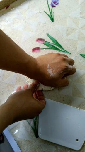 继续用手掌的根部来揉面团，另一只手在底下帮个忙，扶一下面团