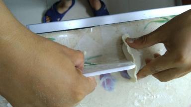 然后一个手拿着刮板，另一只手顶着后面。刮板顶进去，后面的手指顺势捏一下。