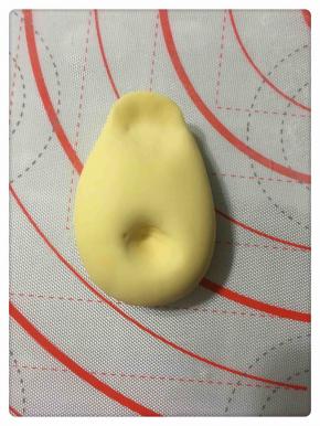 将大面团按出大黄鸭的身体造型，如图所示。