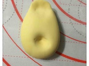 将大面团按出大黄鸭的身体造型，如图所示。