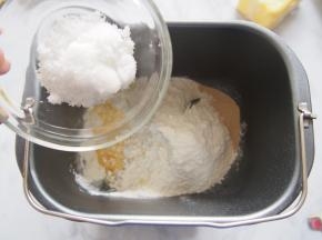 在另外的角落里放入白糖、盐后加入牛奶，揉至光滑。