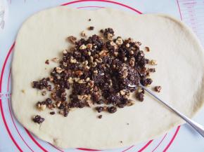 将黄油融化，与红糖、核桃混合均匀成馅，将馅料均匀铺开在面皮上，从一侧卷起并捏紧收口。