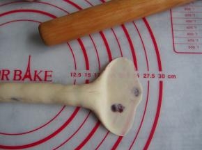 将面团的一端用擀面杖擀成扇形