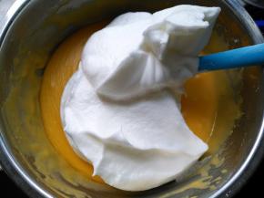 将三分之一蛋白霜放入蛋黄糊，用刮刀翻拌均匀