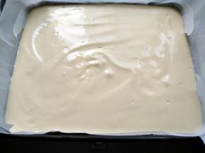 将蛋糕糊倒入铺好油纸的深烤盘，用力震几下