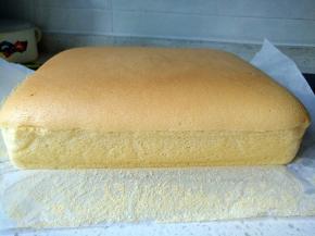 将蛋糕脱模，放在烤网上，揭开四周油纸